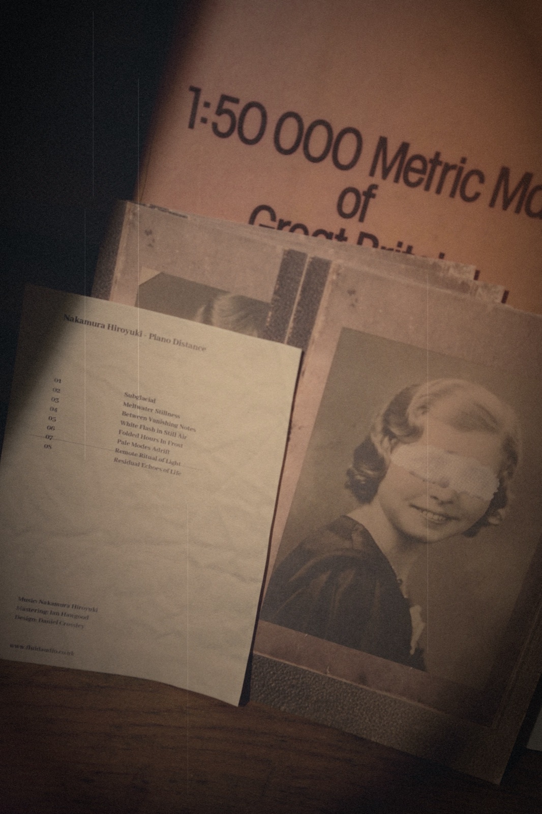 Piano Distance — close detail: printed tracklist insert beside the album's cover portrait (a child with eyes obscured), Fluid Audio handmade CD.